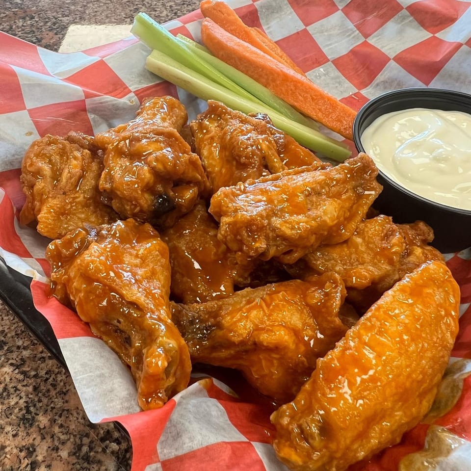 Chief's Steak Shop buffalo wings with celery, carrots, and ranch dressing in a basket.